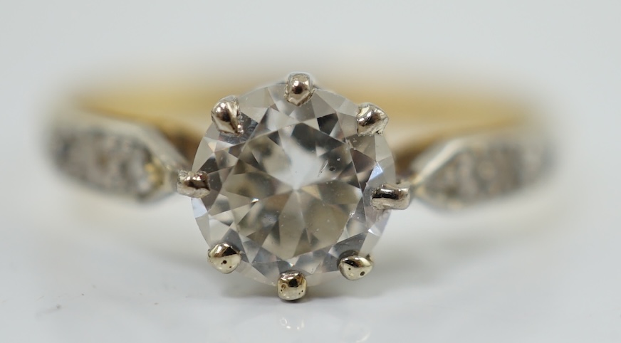 A modern 18ct gold and single stone diamond set ring, with six stone diamond chip set shoulders